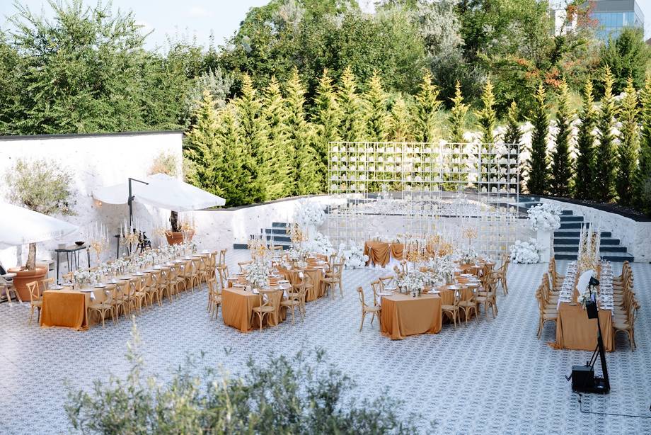 Outdoor terrace venue with round reception tables and white marble paving