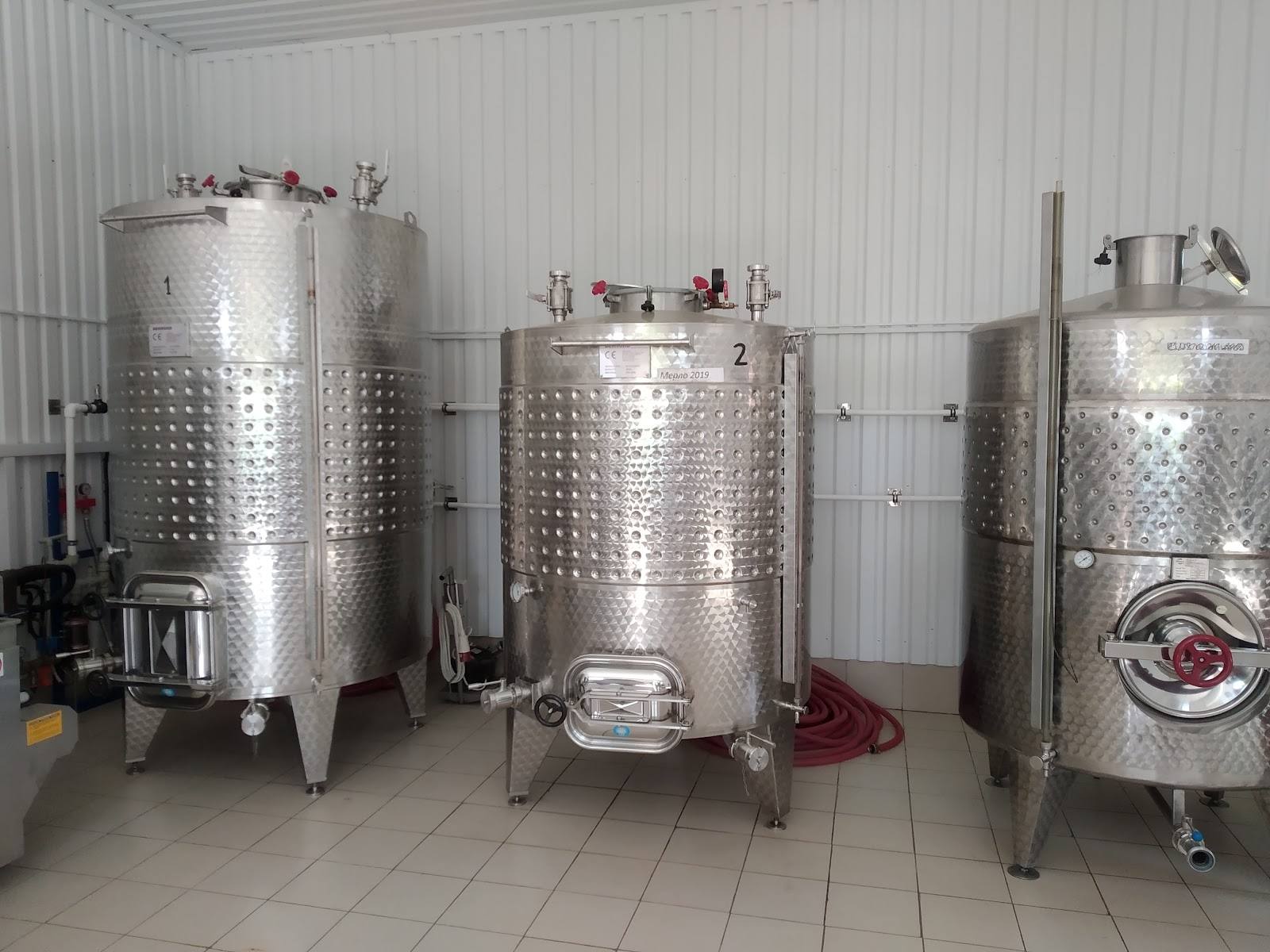 Stainless steel fermentation and storage tanks in modern winery production cellar