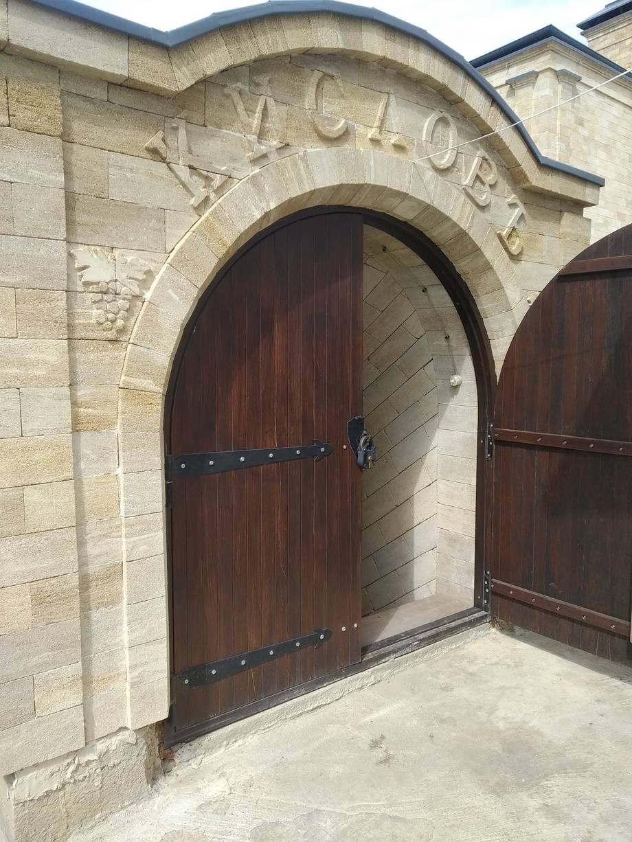 Historic stone cellar entrance with arched doorway and carved signage