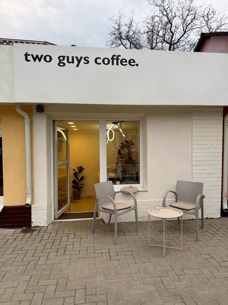 Two Guys Coffee storefront with minimalist design and outdoor seating area