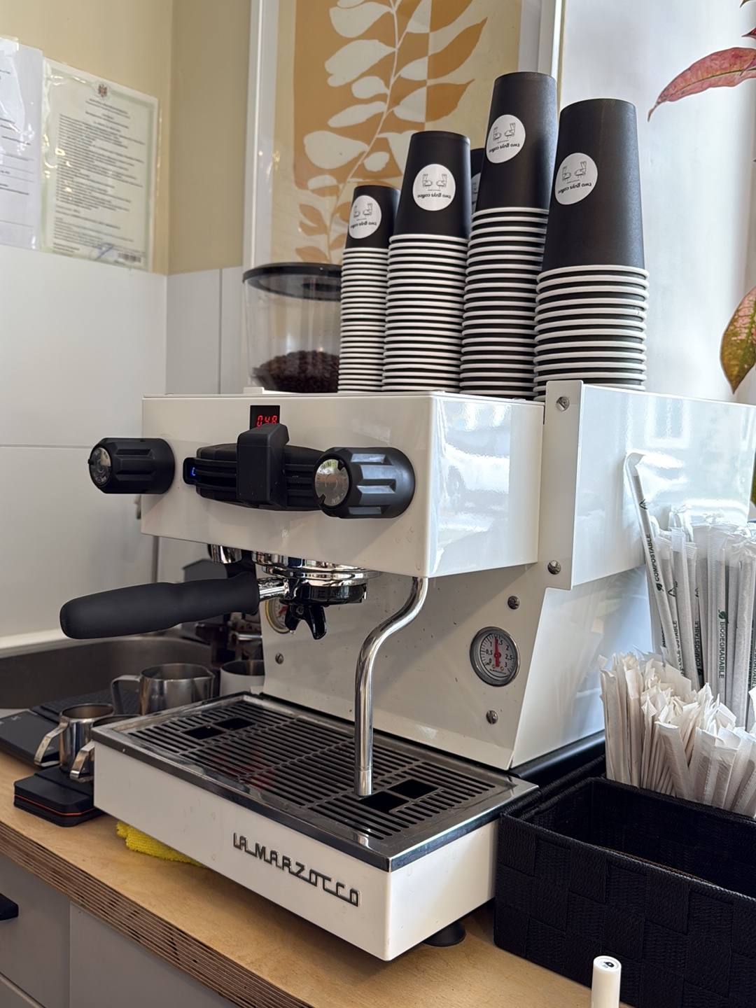 Professional espresso machine with stacked cups at coffee bar station