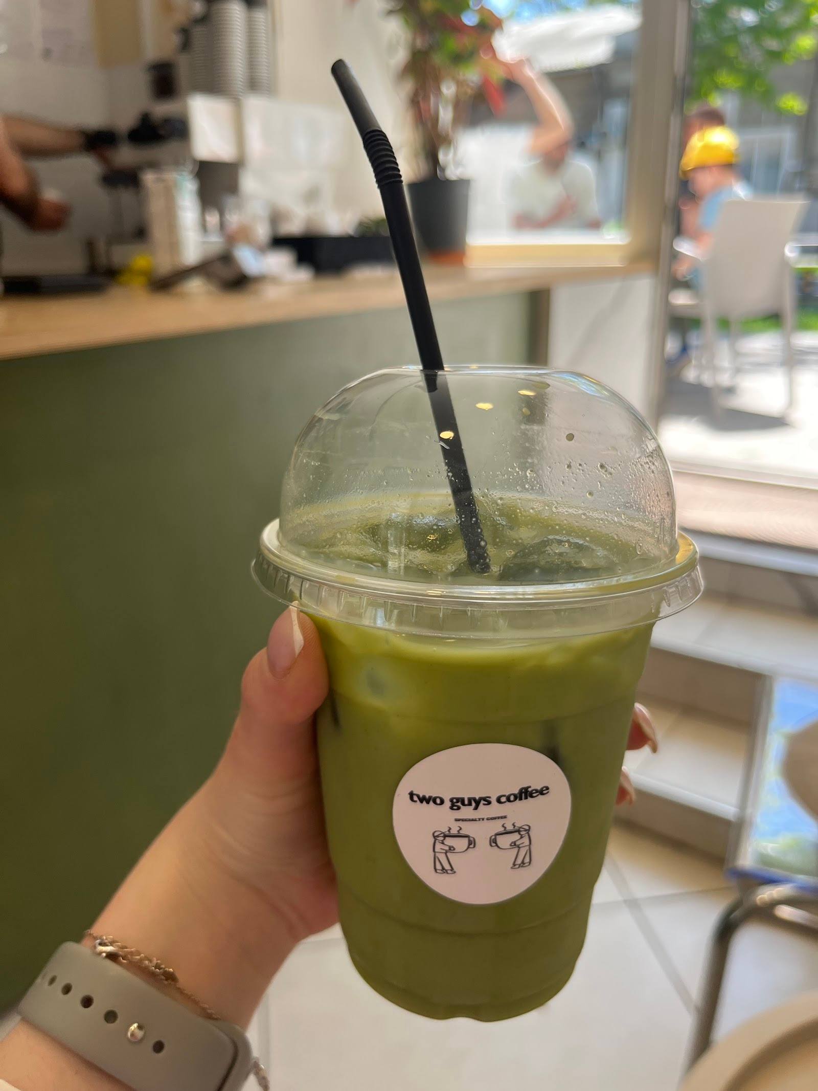 Matcha latte served in branded cup at Two Guys Coffee cafe