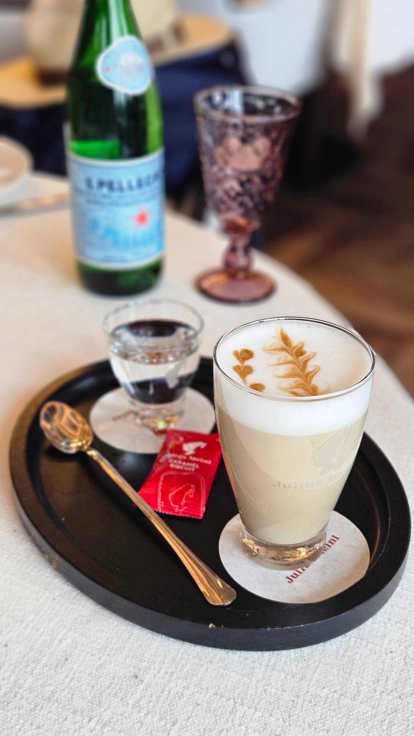 Styled coffee and sparkling water service with artisanal plating on black tray