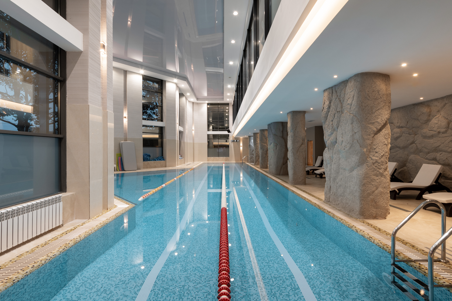 Indoor Olympic-size swimming pool with lane markers and modern architectural elements