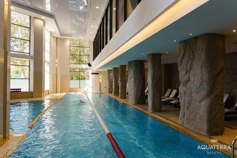 Modern indoor swimming pool with lane markings and stone columns