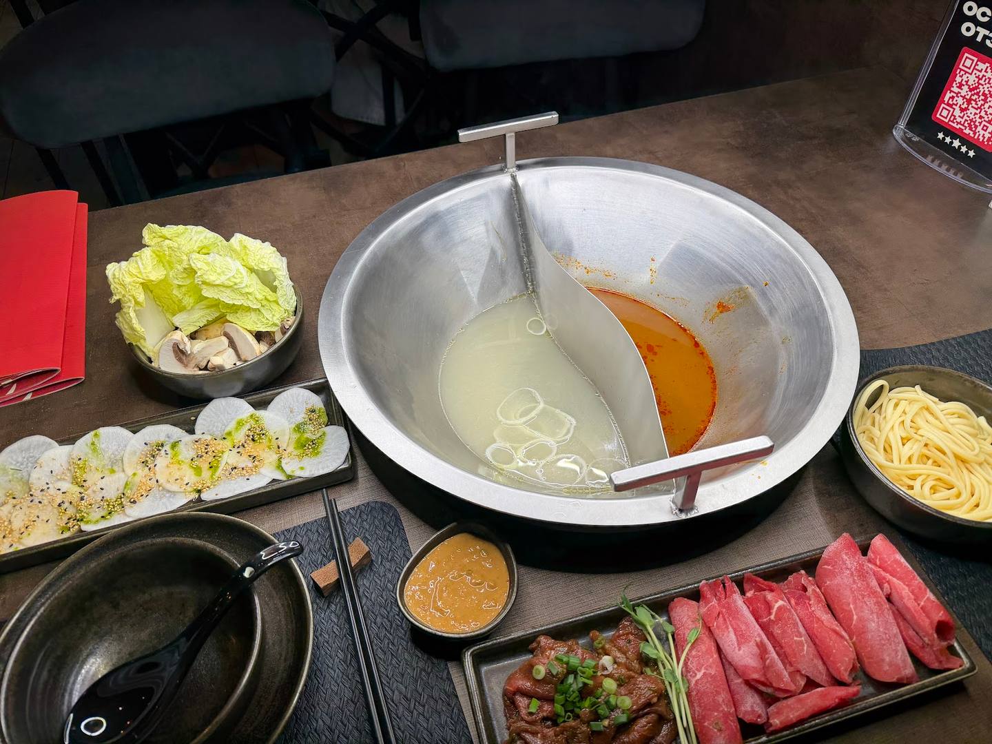 Hot pot and shabu-shabu ingredients laid out on dining table