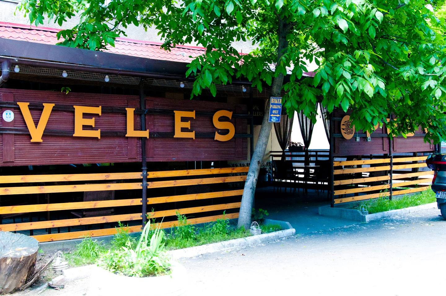 Veles venue exterior with distinctive yellow and black signage and wooden fence