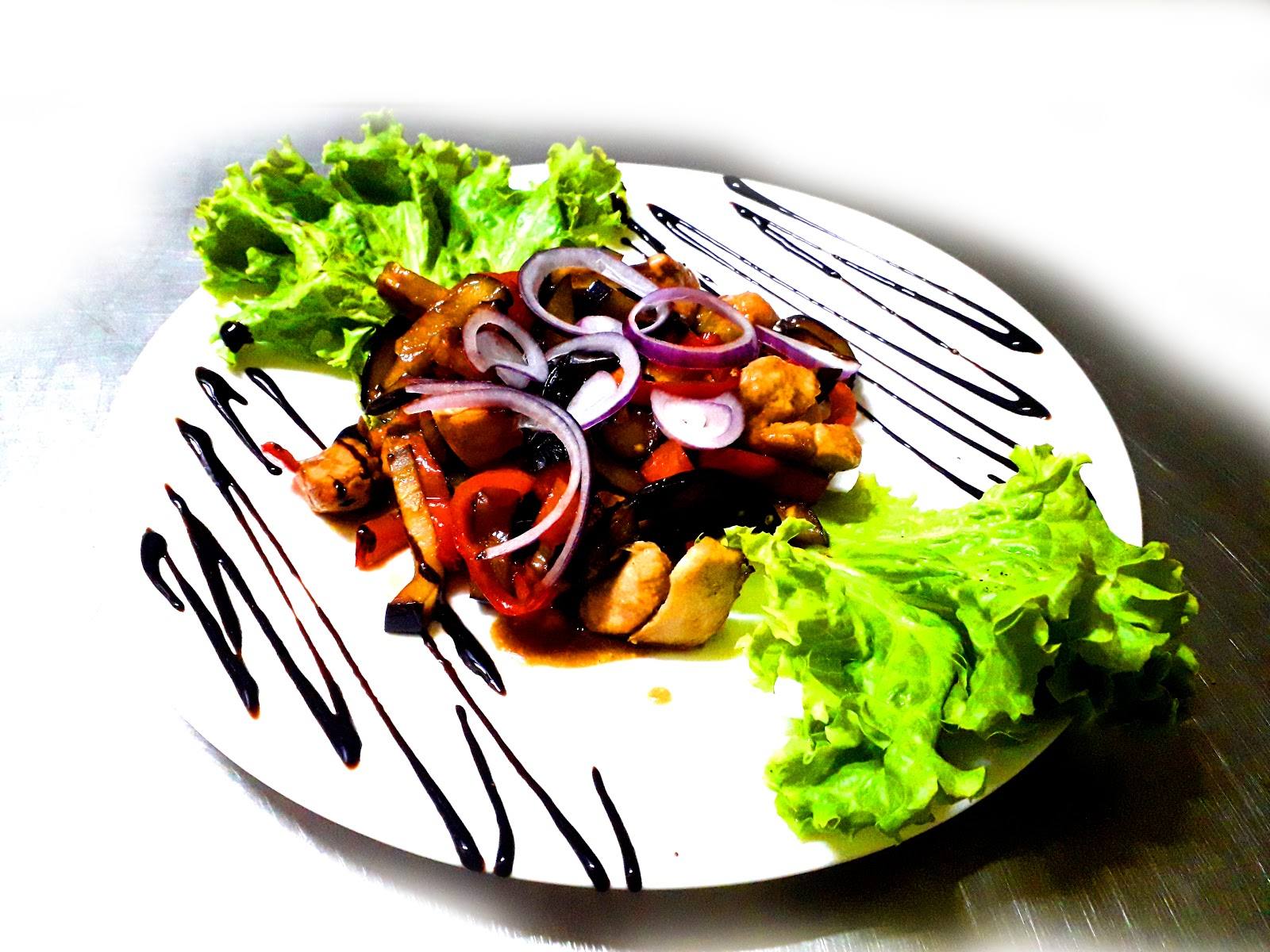 Plated vegetable and meat dish with artistic sauce presentation