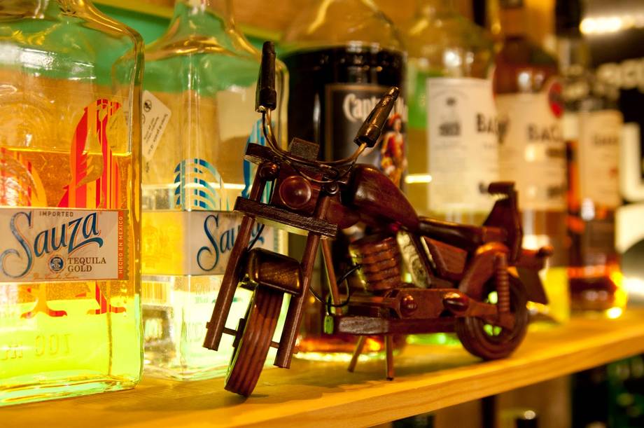 Bar counter display with miniature motorcycle and bottles of liqueur