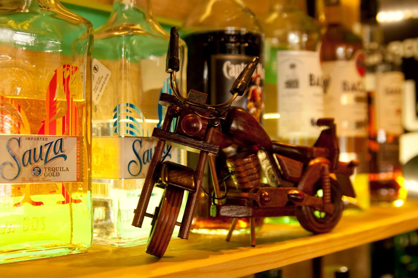Bar counter display with miniature motorcycle and bottles of liqueur