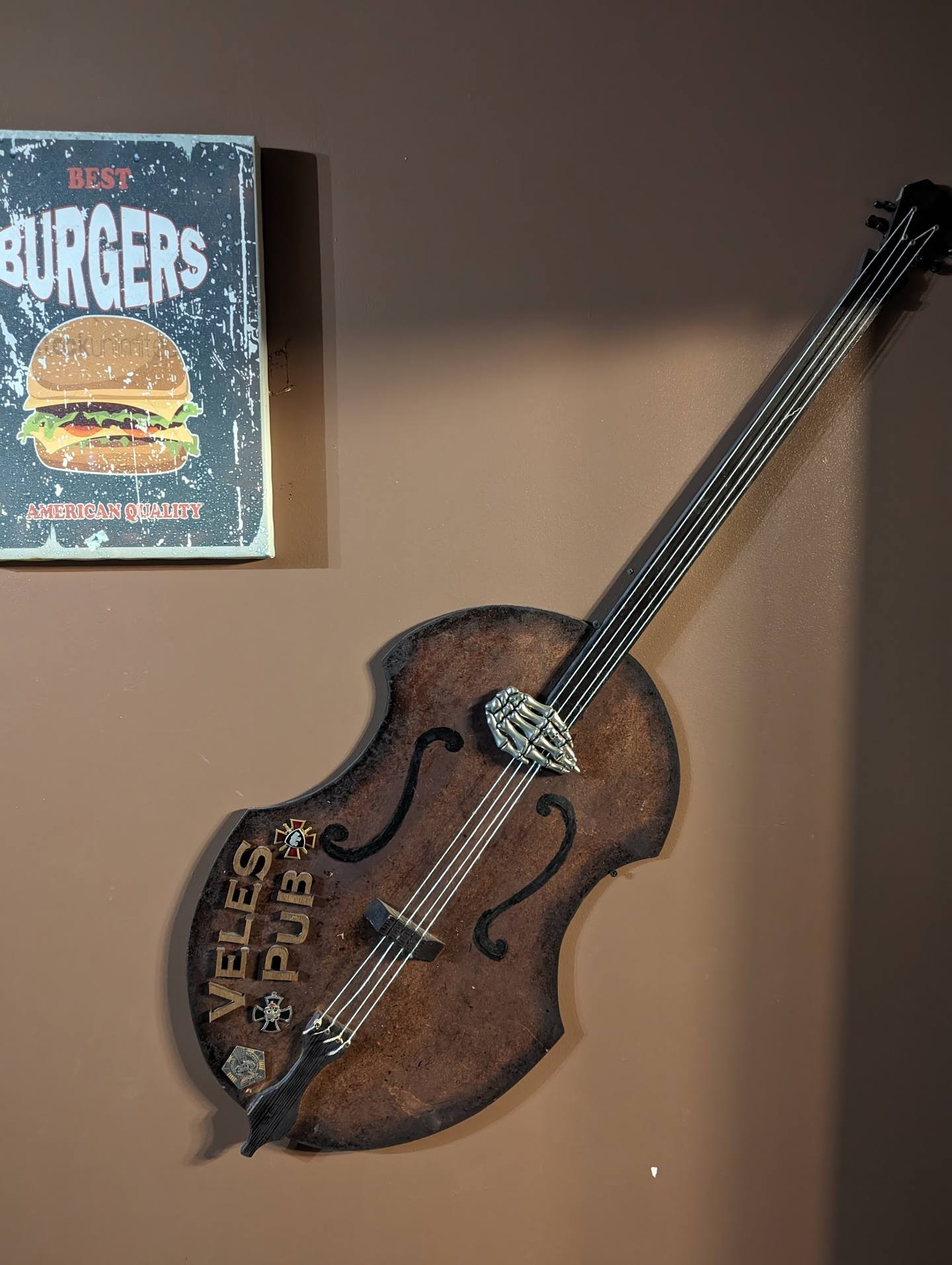 Decorative violin and vintage burger sign on interior wall