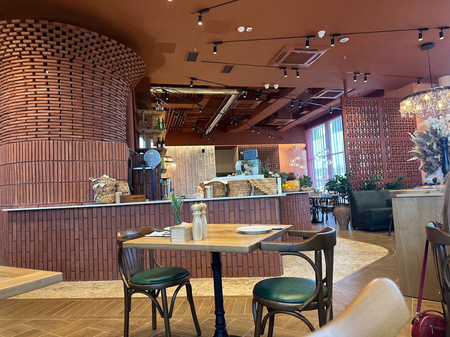 Modern café interior with wooden accent wall, dining tables, and service counter