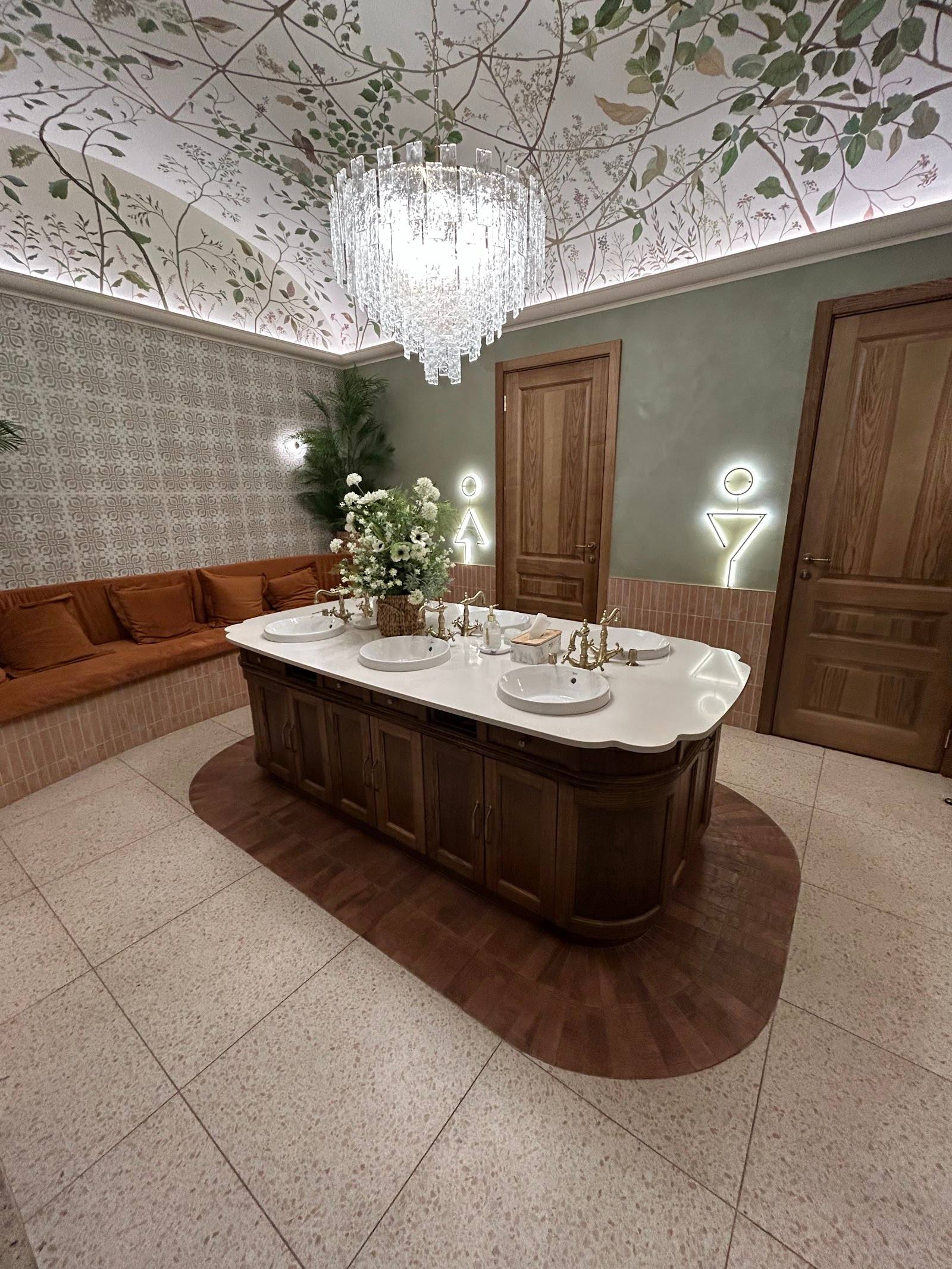 Elegant spa treatment room with statement ceiling, marble island counter, and relaxation seating area