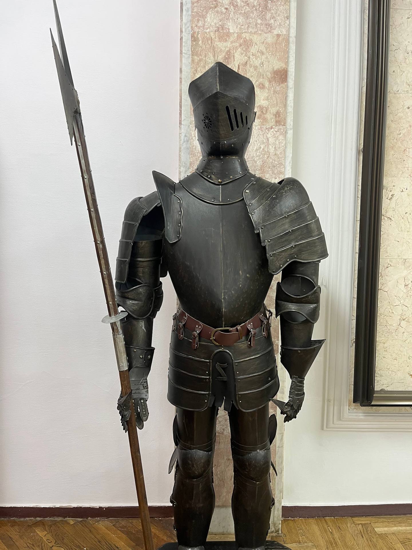 Medieval knight armor on display with halberd weapon