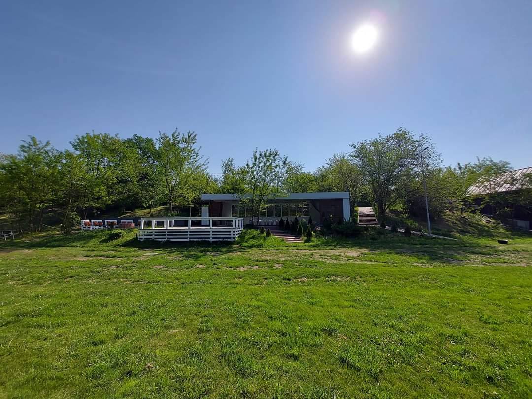 Outdoor venue with modern pavilion structures set in spacious green field