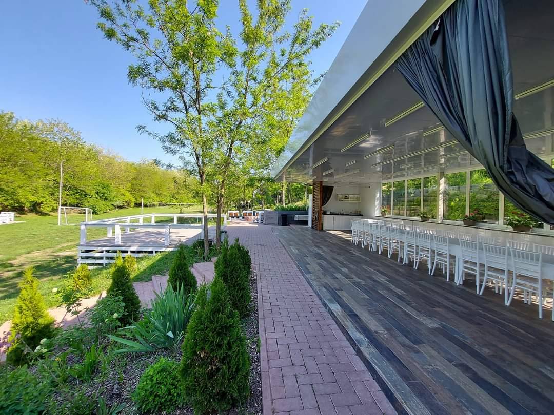 Open-air pavilion terrace with lake view and manicured landscaping in natural setting