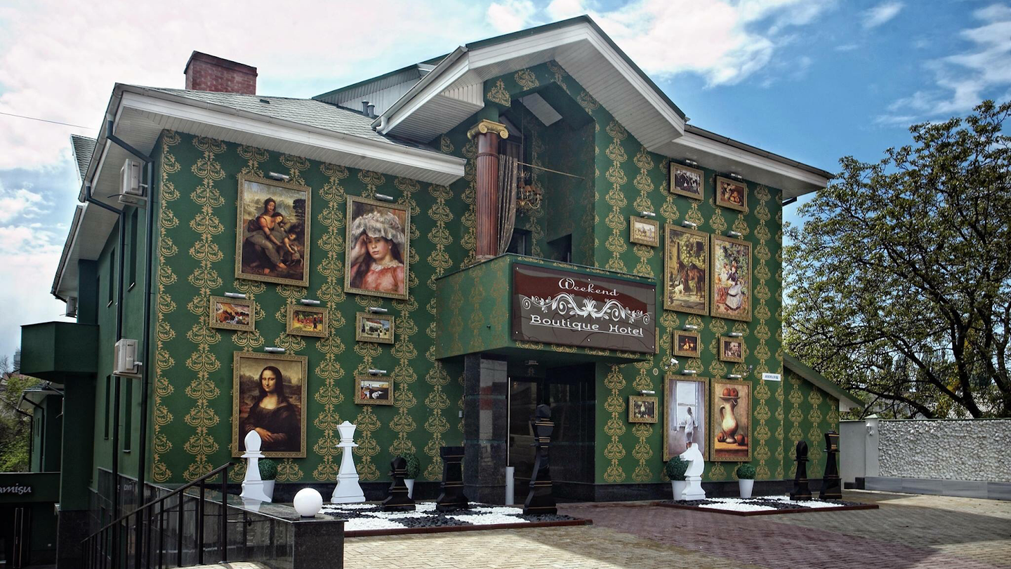 Art gallery storefront with ornate green facade and portrait collection display