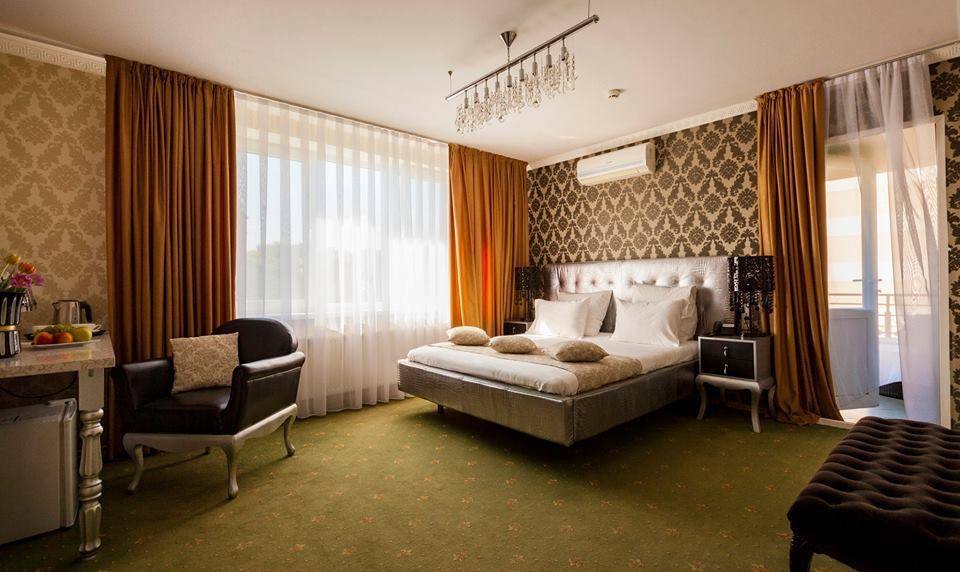 Elegant hotel bedroom suite with luxurious furnishings and warm drapery