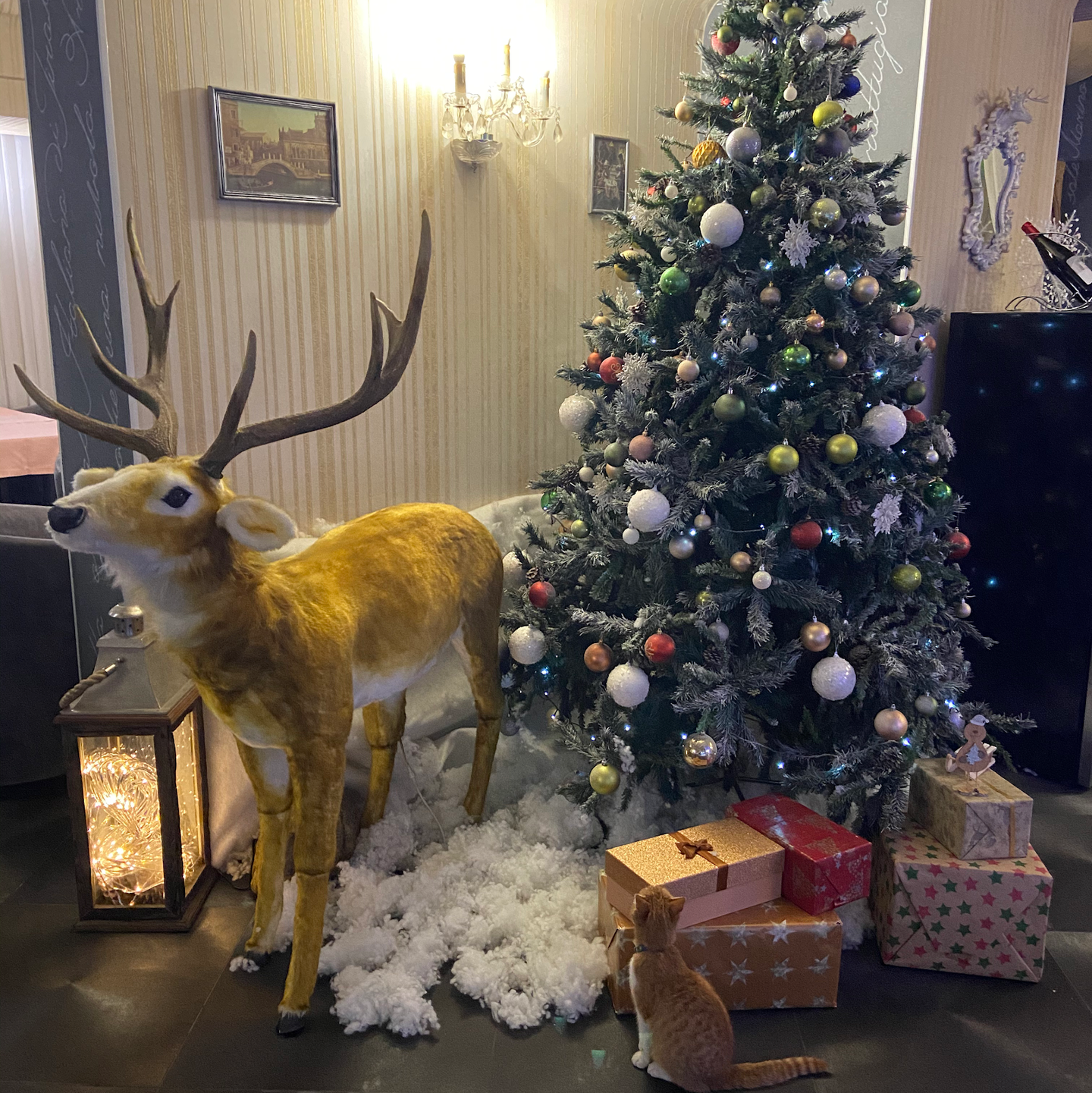 Holiday-themed interior decoration with golden reindeer and decorated Christmas tree display