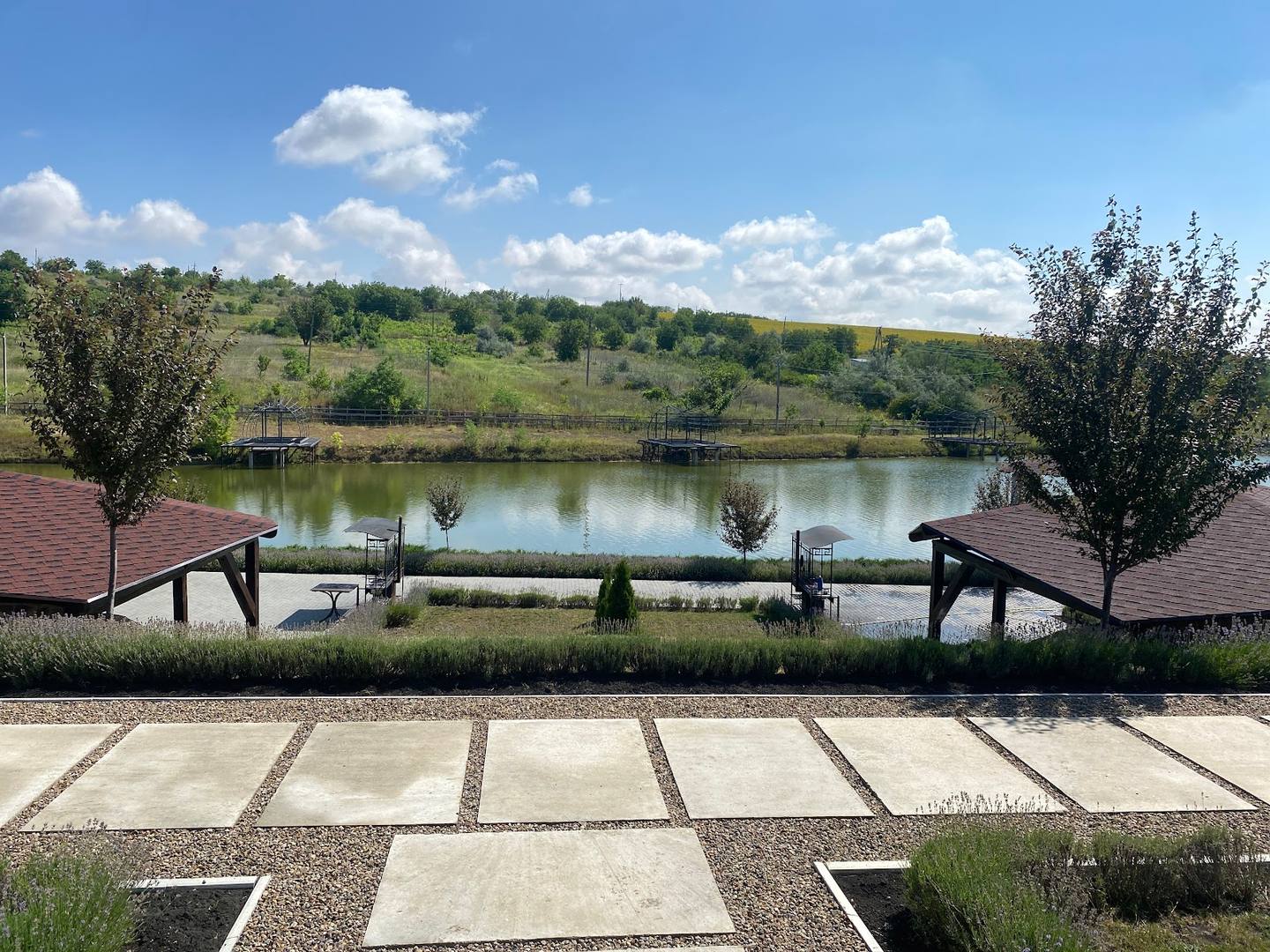 Waterfront terrace overlooking a scenic pond with manicured landscaping and natural surroundings