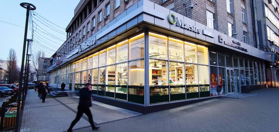 Modern storefront with illuminated corner facade and street level visibility in urban setting