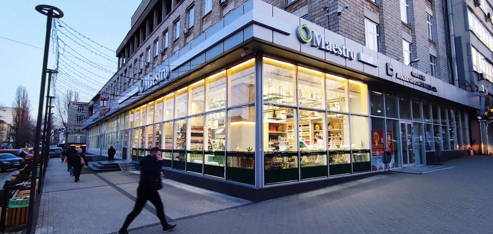Modern storefront with illuminated corner facade and street level visibility in urban setting