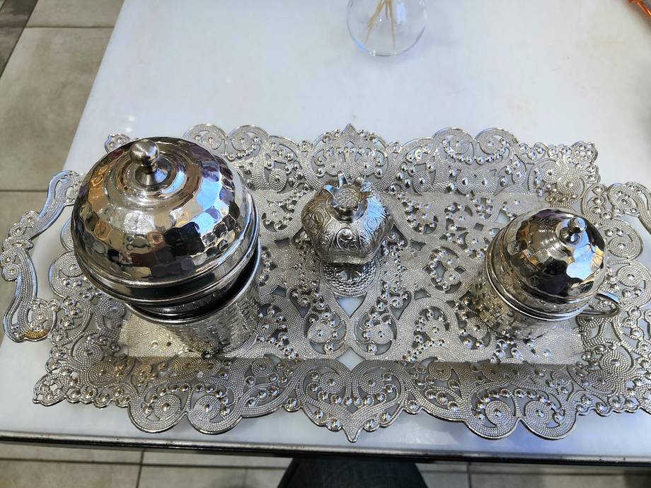 Silver serving domes and decorative lace placemat table setting