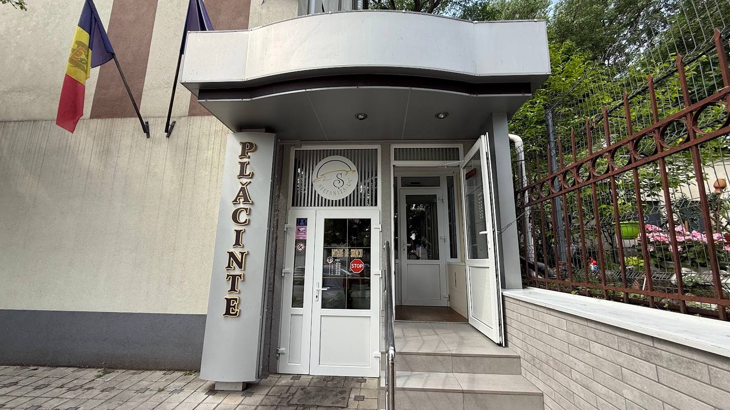 Modern white storefront with elegant canopy and Romanian flag signage