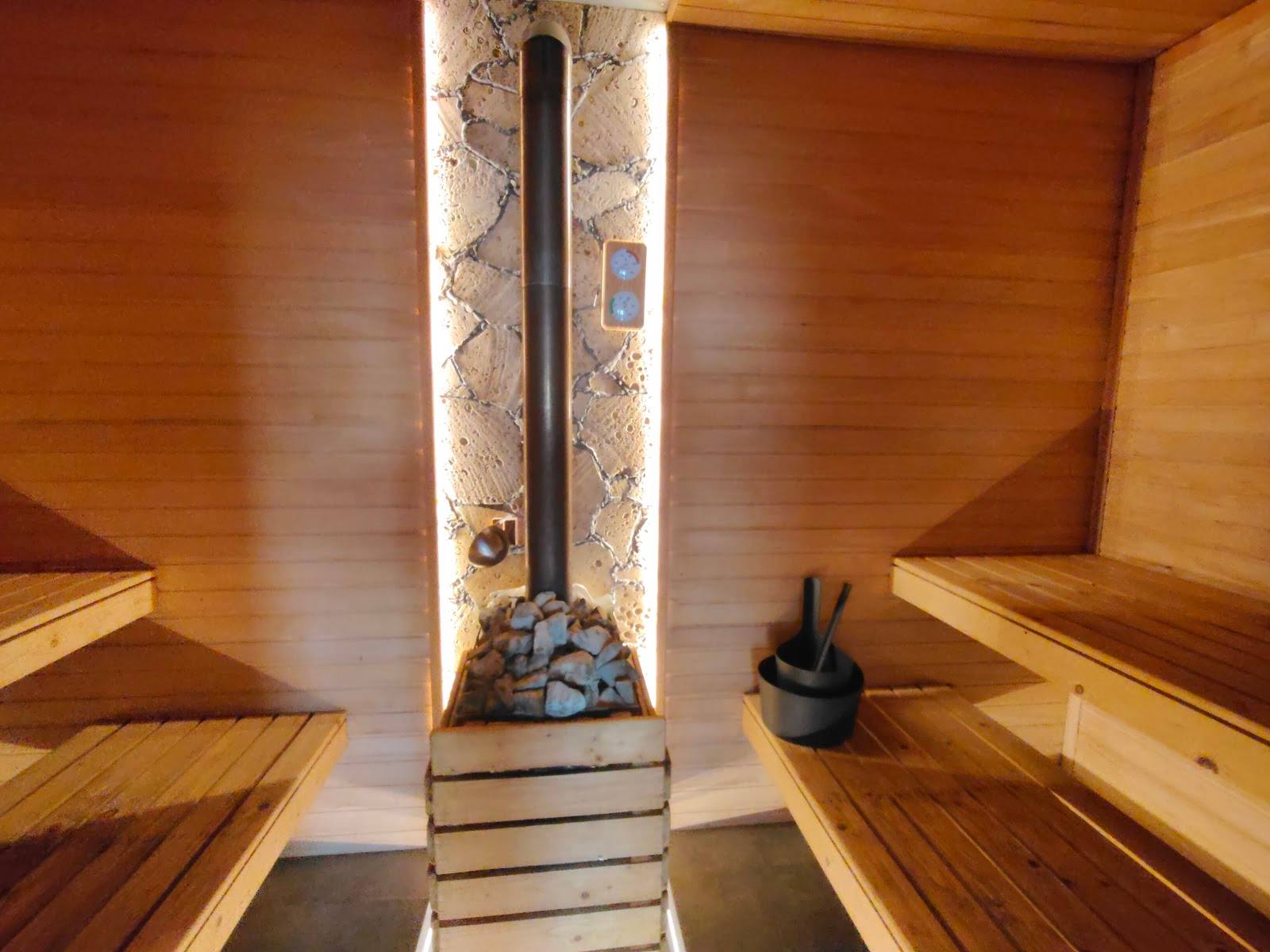 Traditional wooden sauna interior with central heater and steam stove
