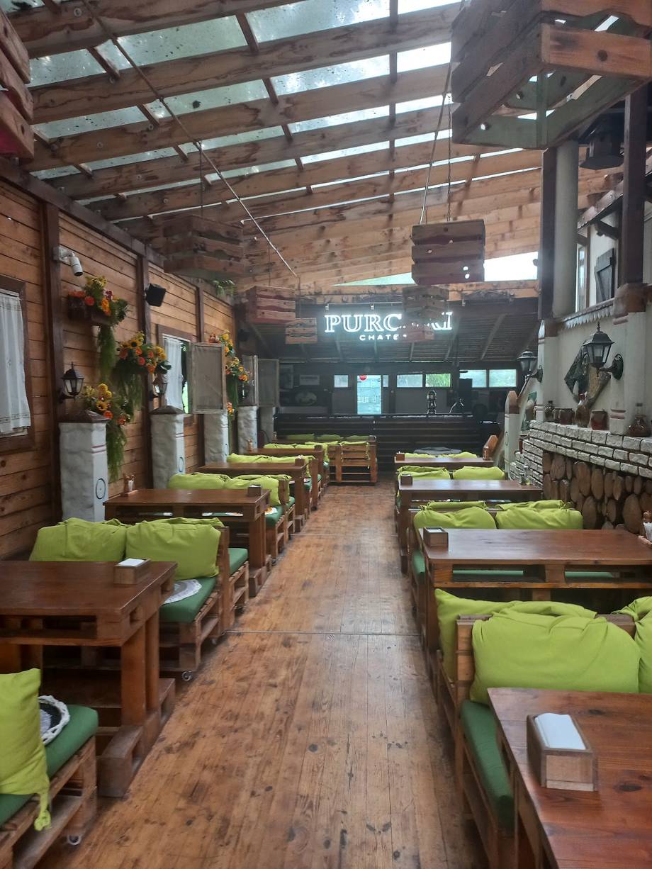 Rustic pub interior with wooden tables, lime green cushions, and industrial ceiling