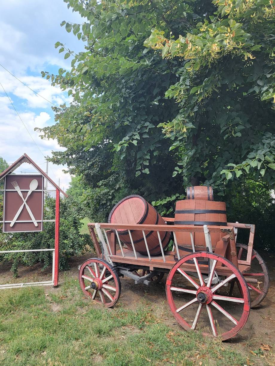 Rustic red wagon and barn structure in countryside setting