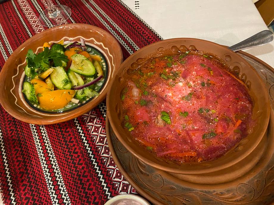 Two traditional clay dishes with vegetables and stew on embroidered cloth
