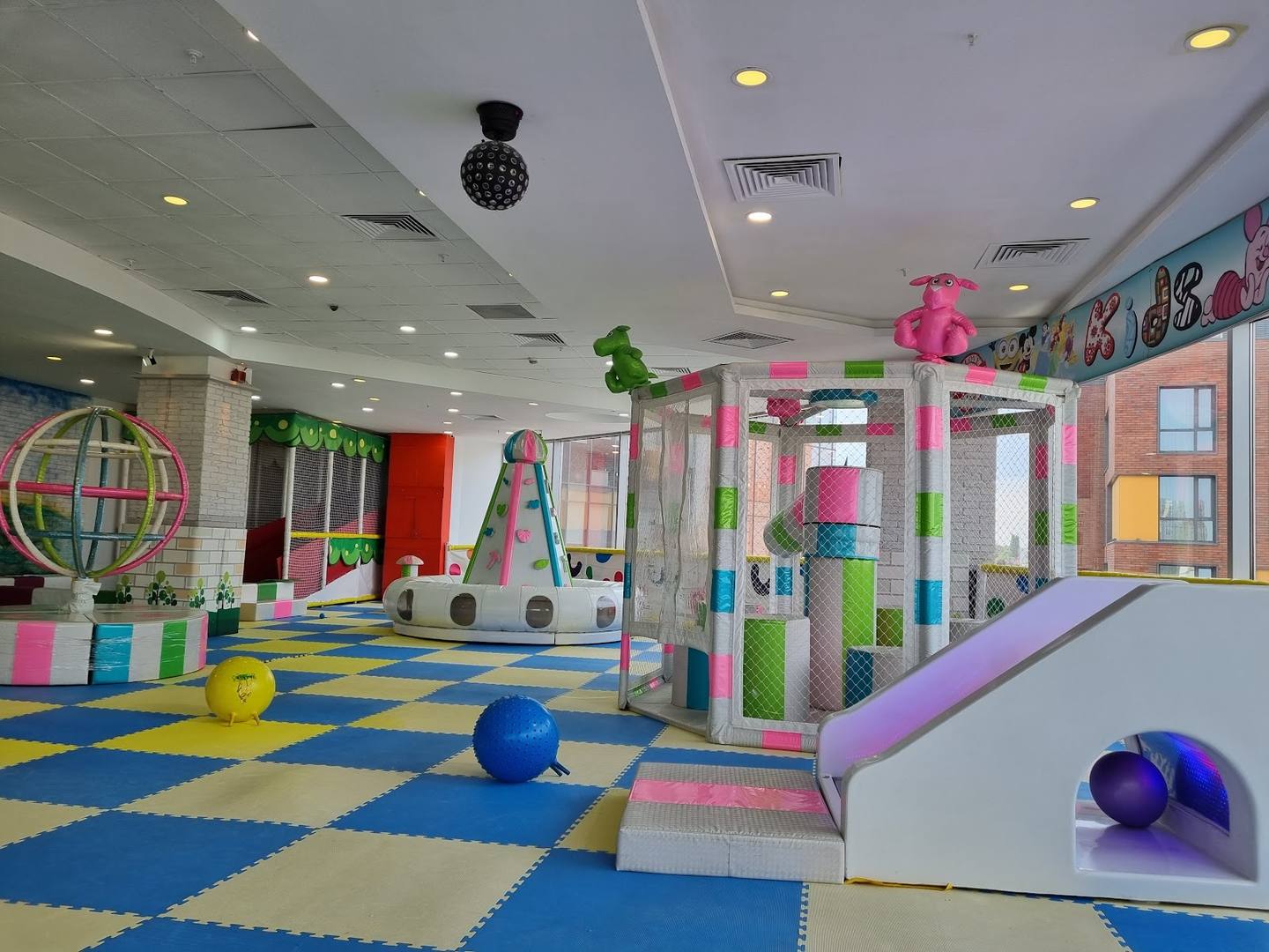 Colorful indoor play center with soft play structures, foam pit, and padded flooring