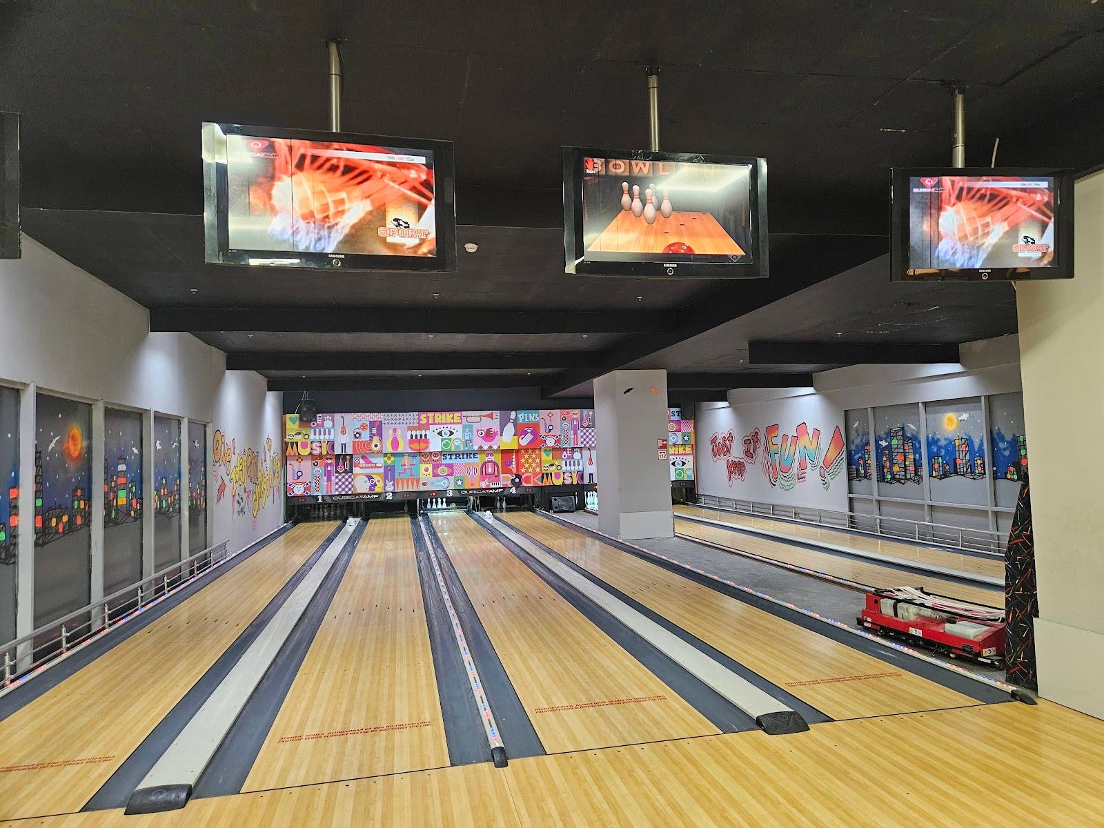 Bowling alley with multiple lanes, scoring displays, and modern lighting