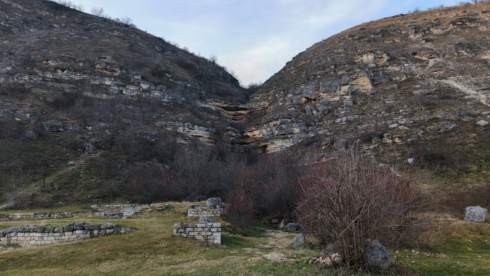 Mountain gorge with stone ruins and hiking trail access