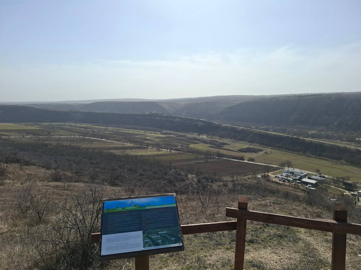 Panoramic valley viewpoint with interpretive signage overlooking rolling landscape