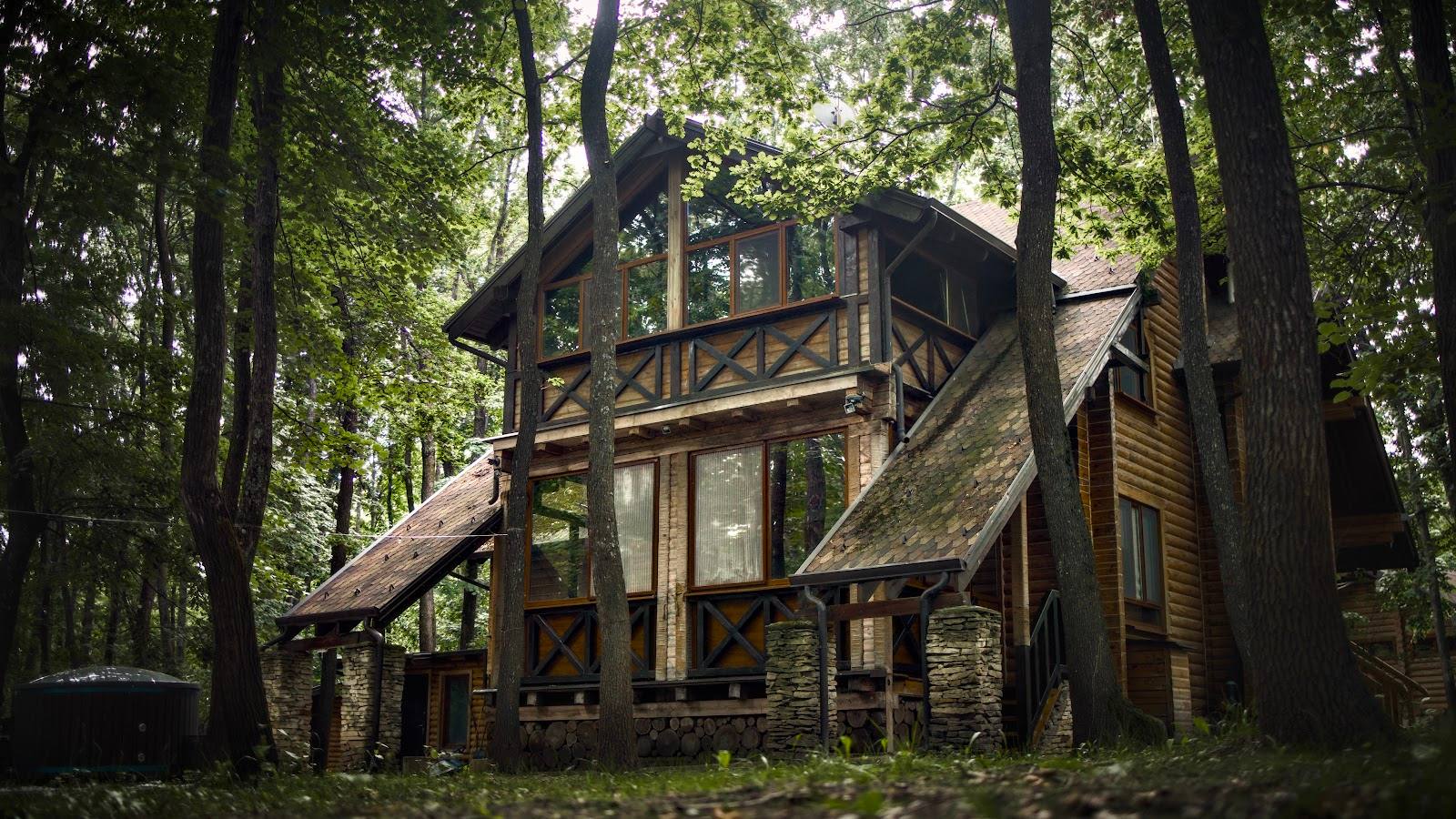 Woodland cottage exterior with elevated deck among tall forest trees