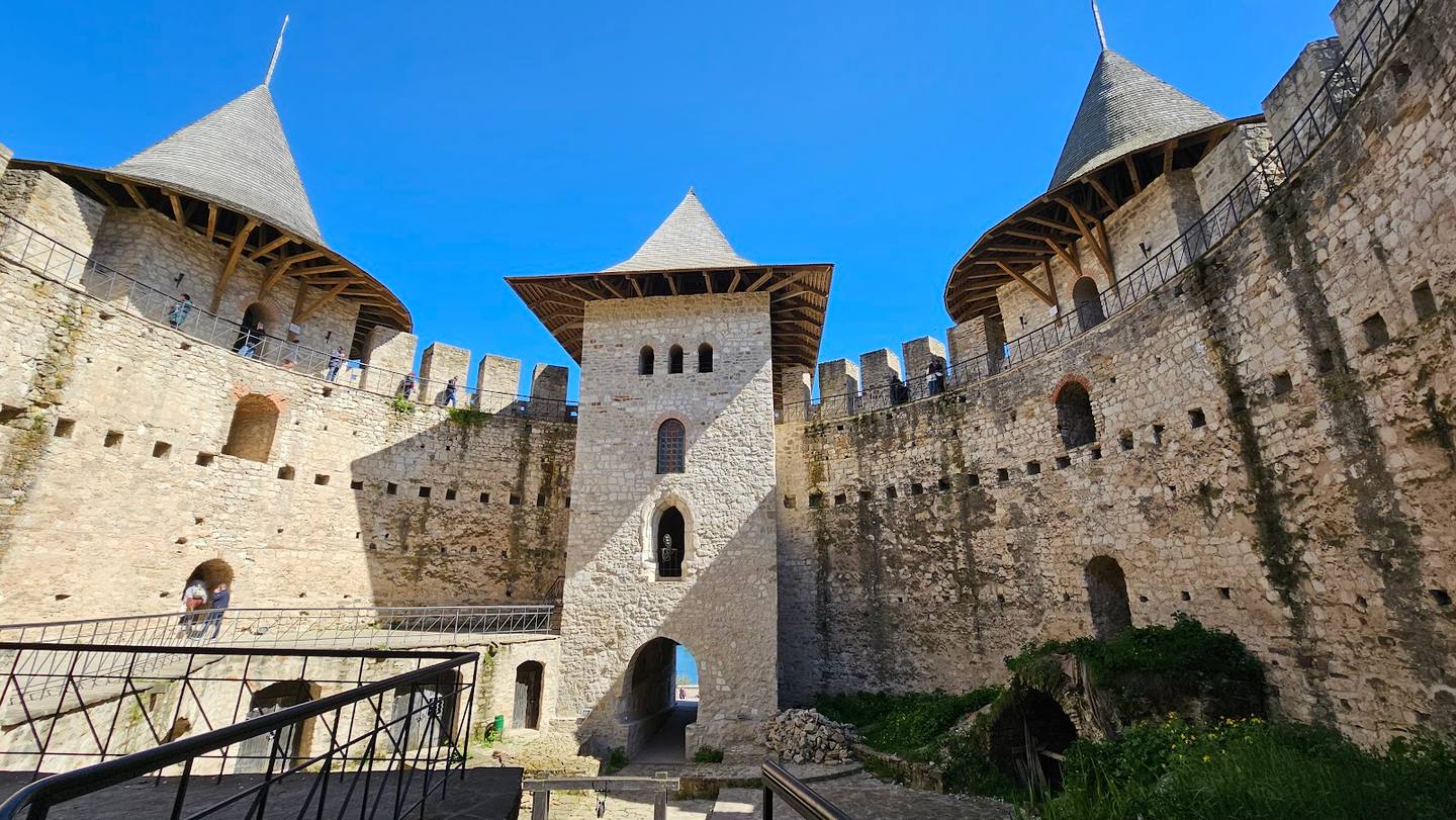 Medieval fortress with distinctive turrets and stone fortifications under clear sky
