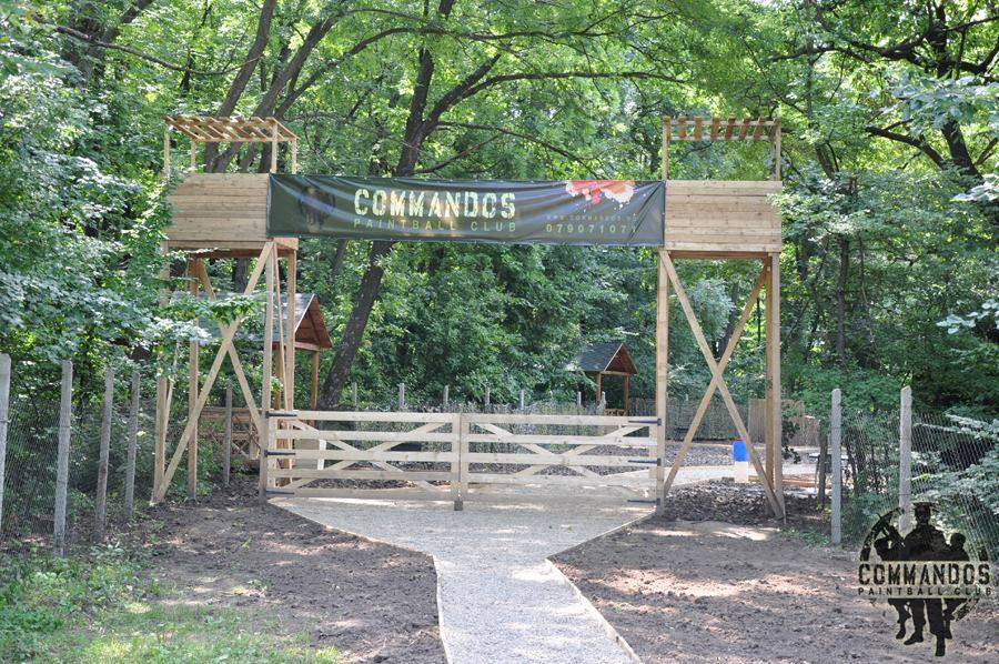 Wooden entrance gate with "Comandos" signage at outdoor activity venue