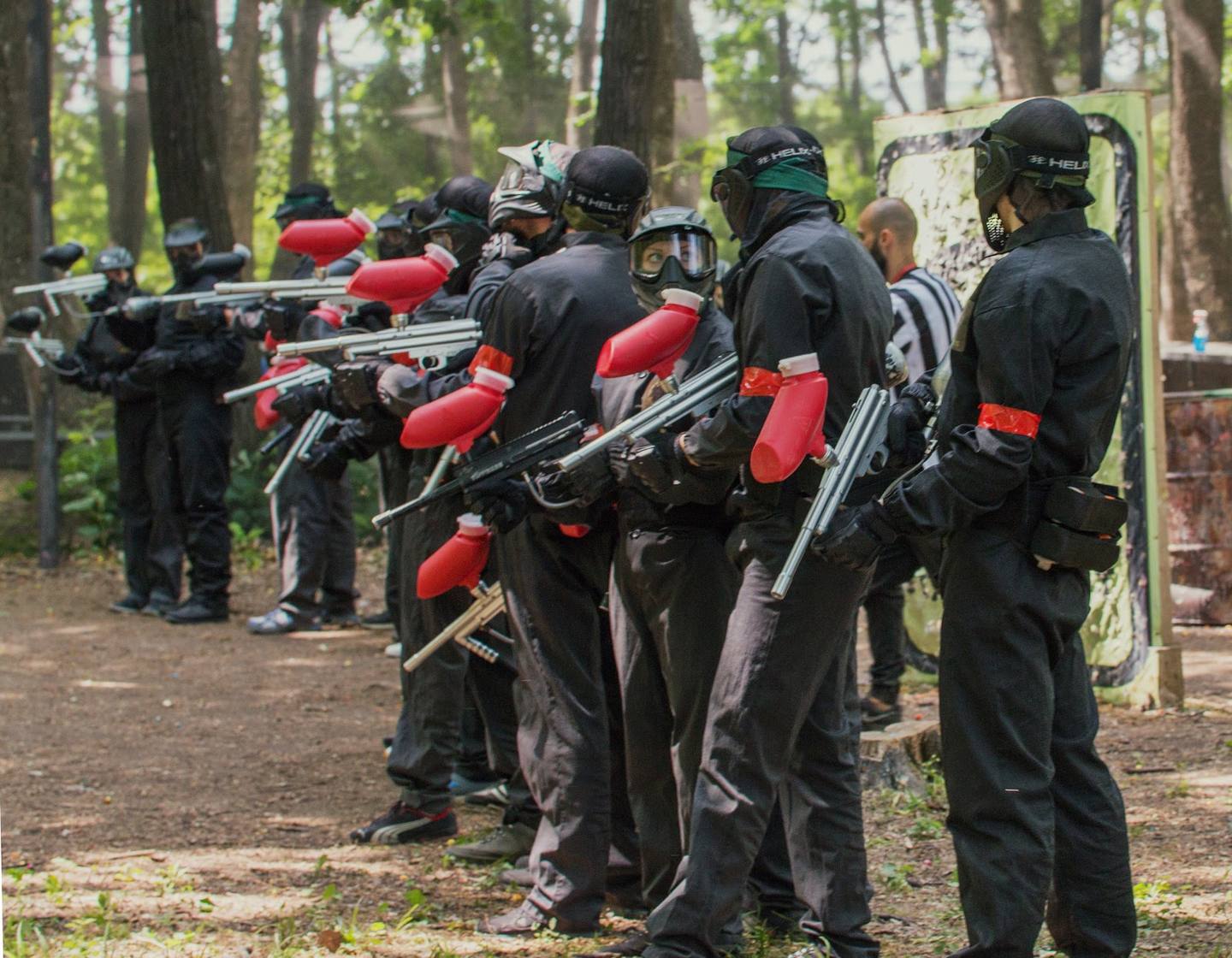 Paintball players in combat gear during outdoor woodland game session