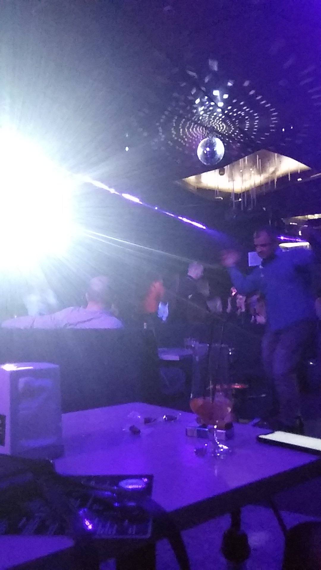 DJ booth and dance floor with purple stage lighting and crowd