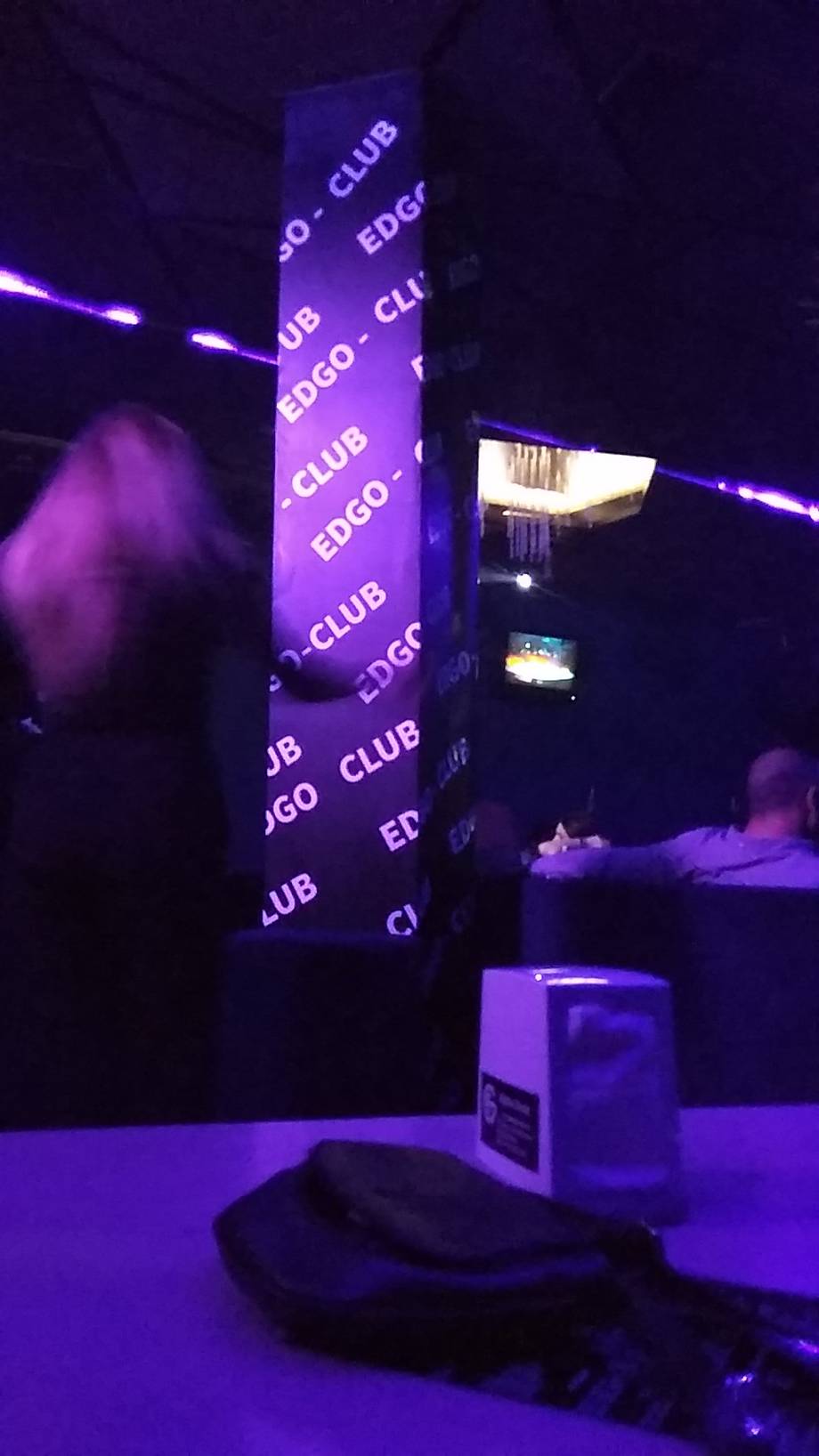 Purple neon-lit club interior with EDGO signage and dancefloor ambiance