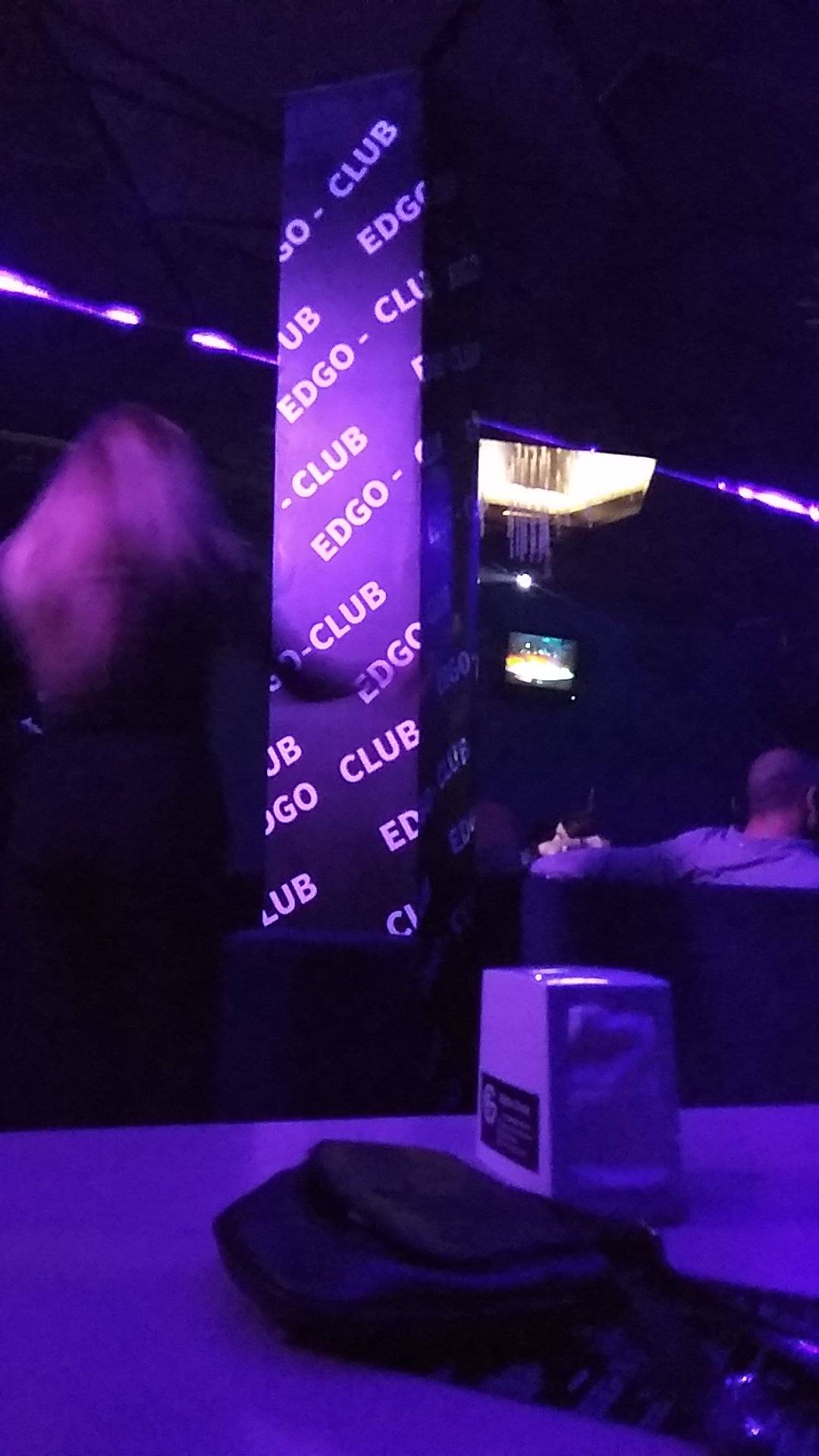 Purple neon-lit club interior with EDGO signage and dancefloor ambiance