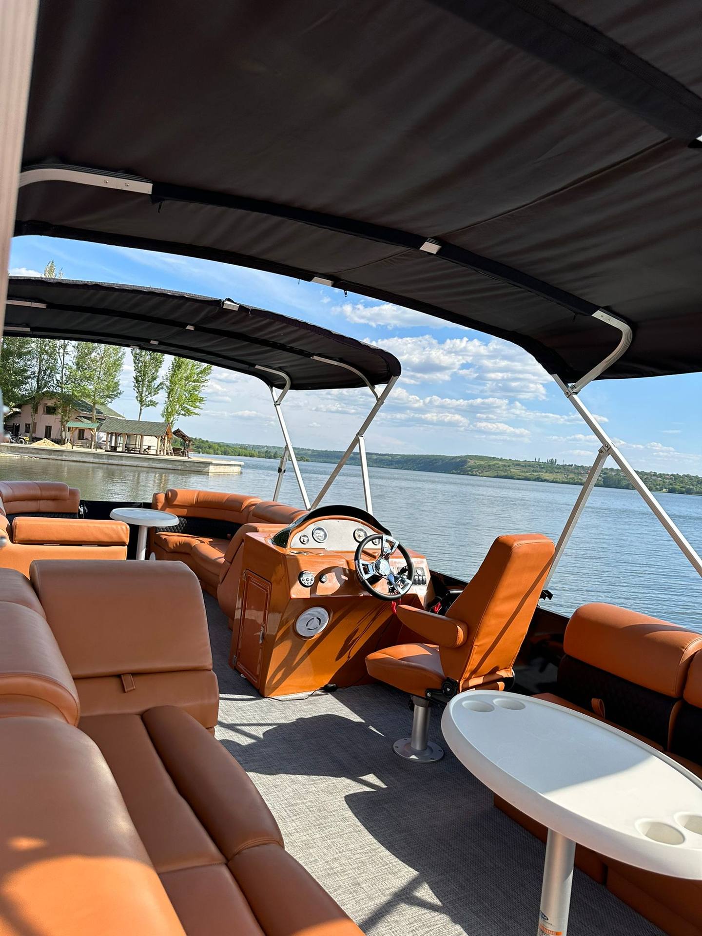 Luxury boat interior with orange leather seating and waterfront view