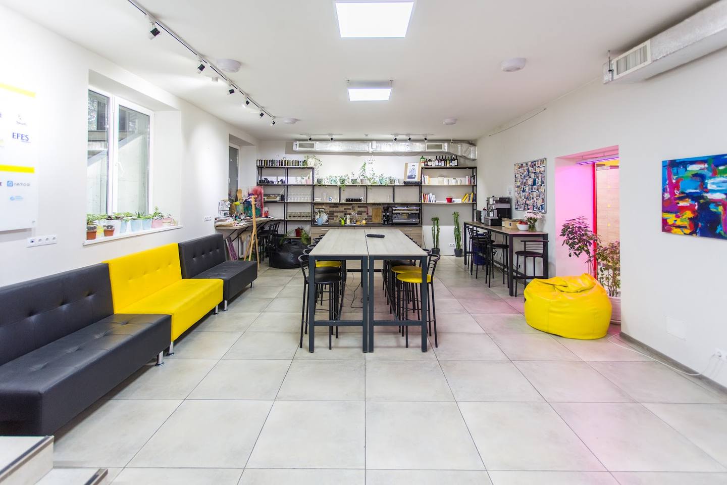 Modern interior with seating areas, café counter, and colorful accent furniture