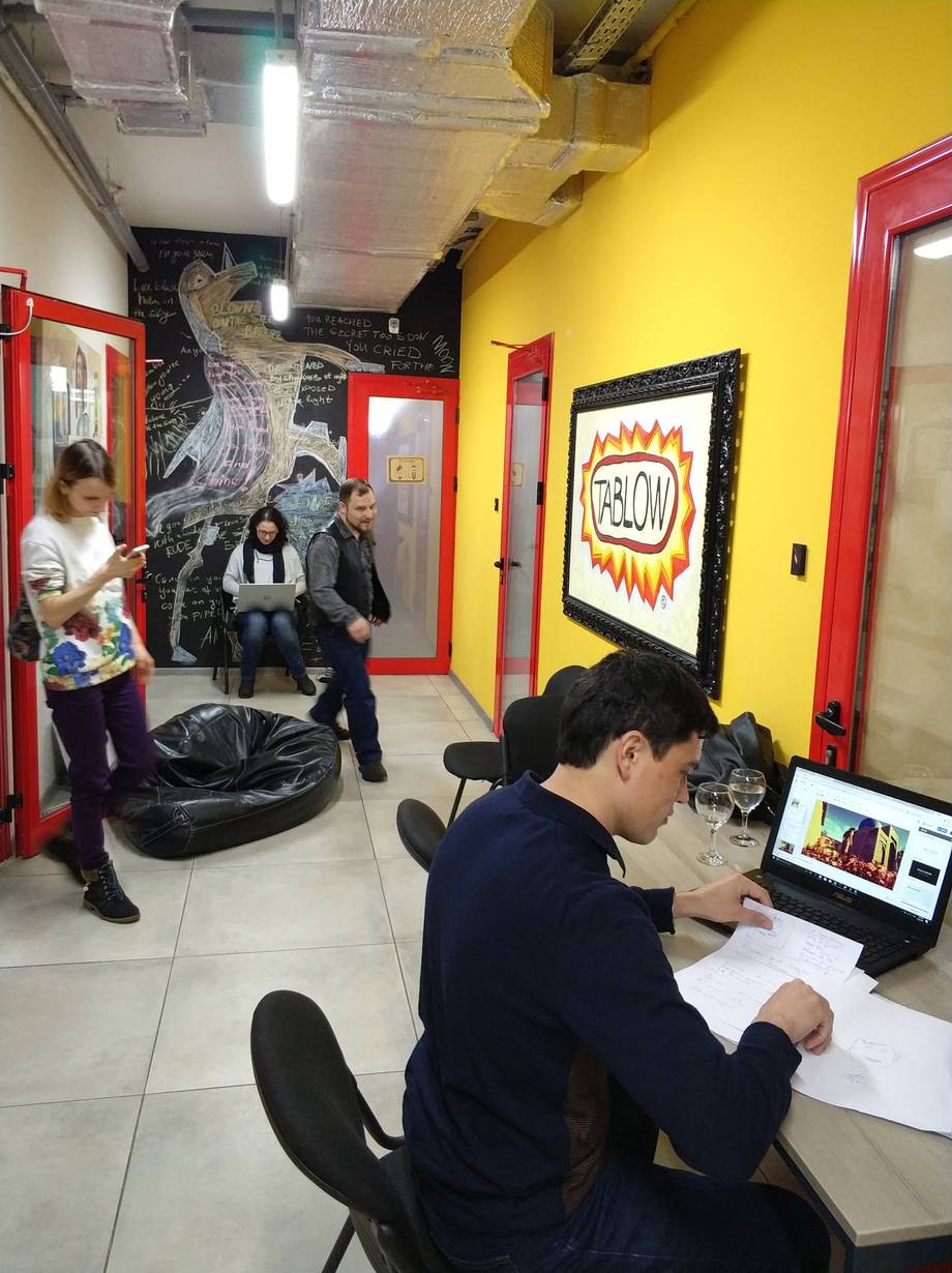 Interior workspace of an escape room or activity venue with bold yellow walls and red door frames