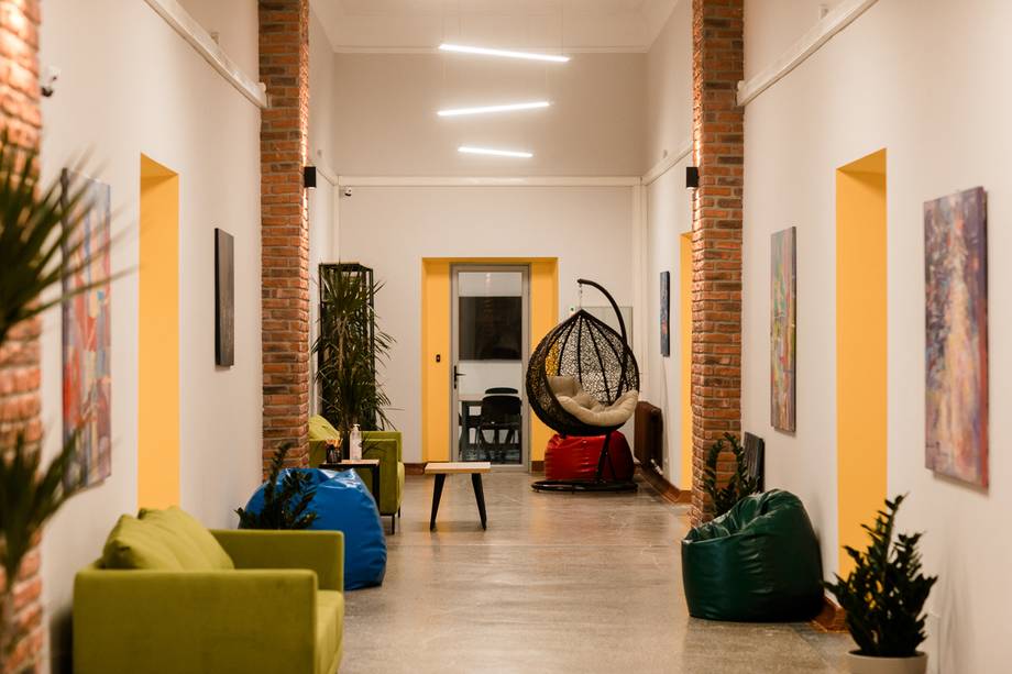 Modern industrial interior with exposed brick, bright yellow accents, and lounge seating