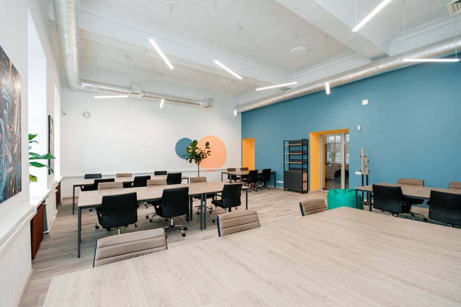 Modern office space with open floor plan, bright lighting, and colorful accent walls