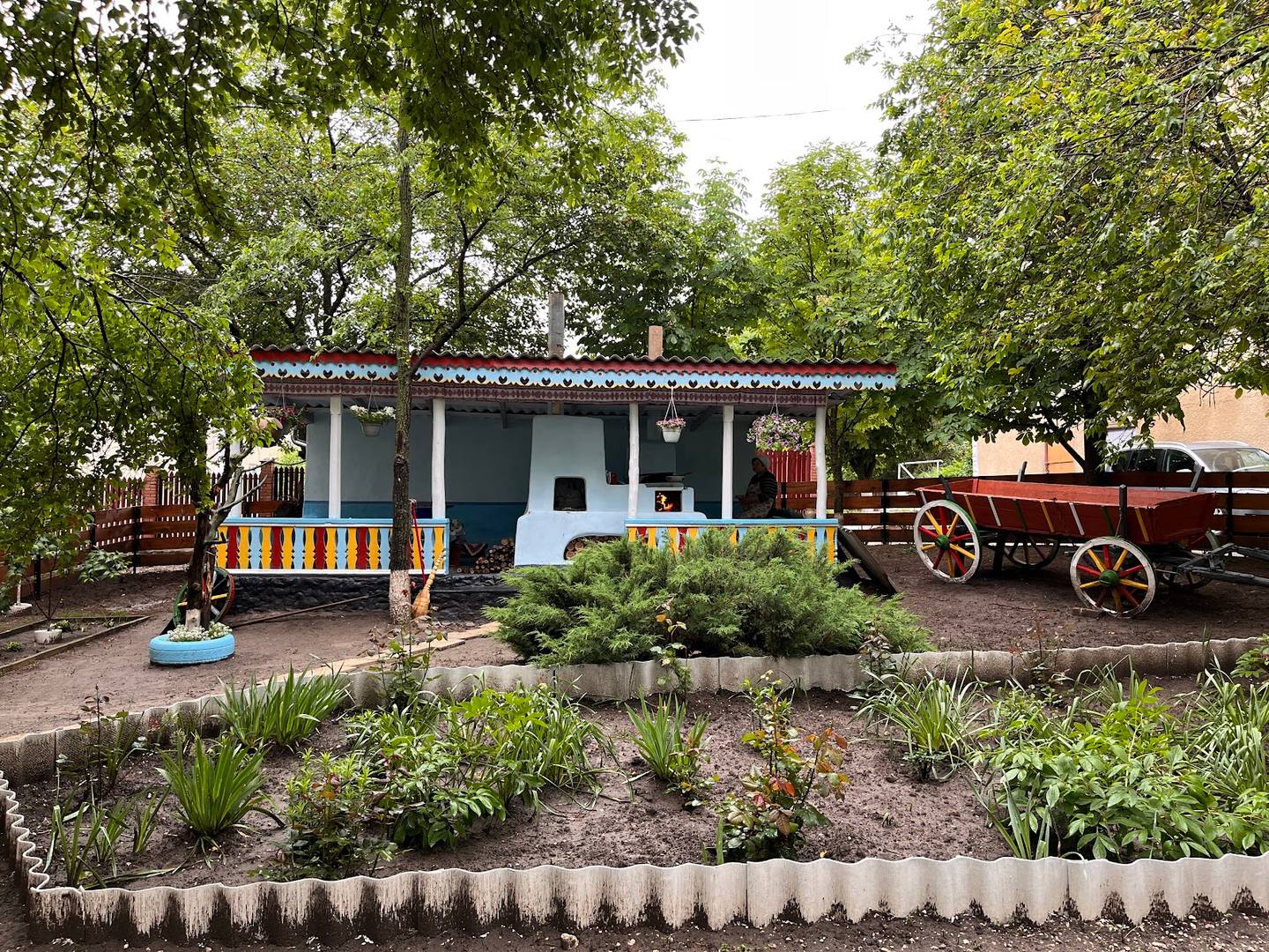 Rustic countryside cottage with garden, vintage wagon, and shaded grounds