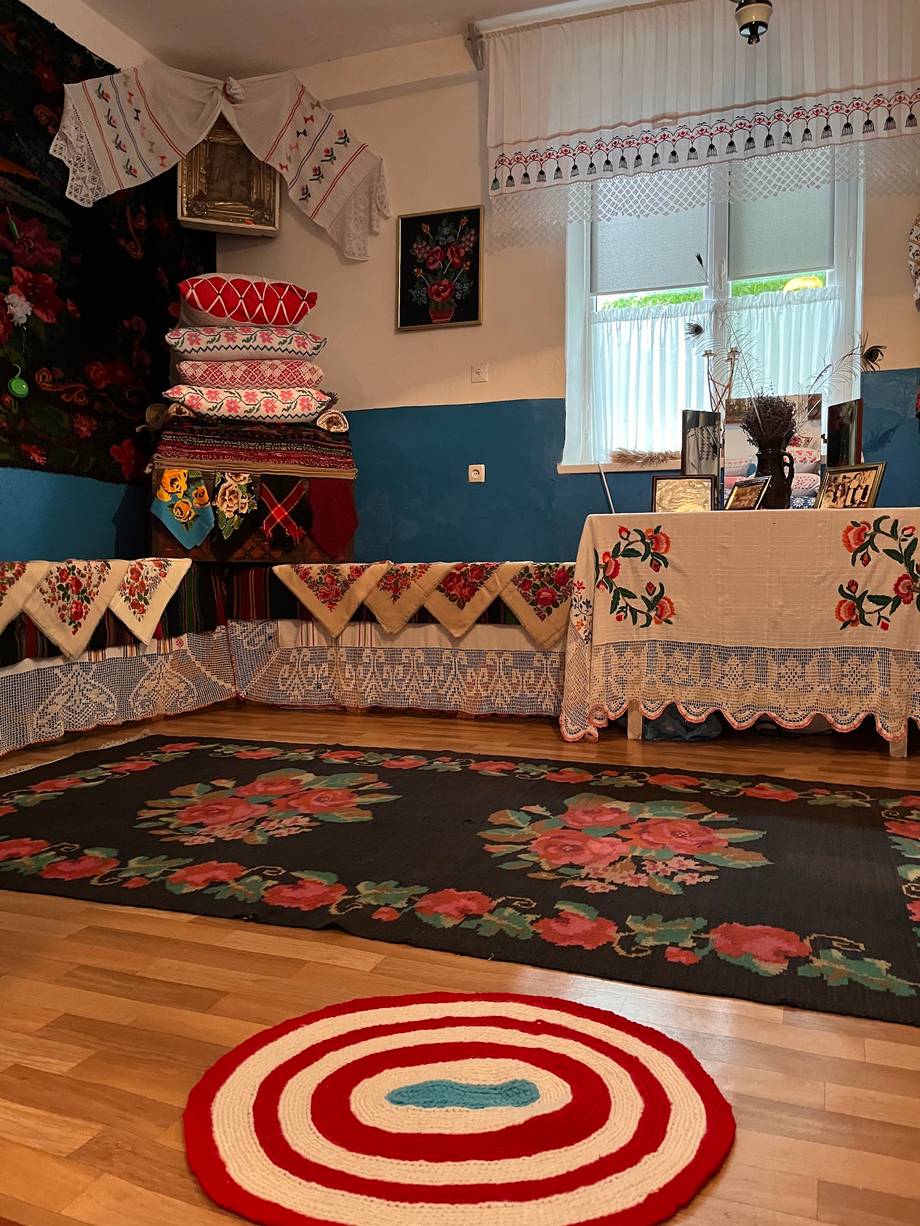 Traditional folk-style interior with ethnic textiles, decorative rugs, and rustic wooden counter